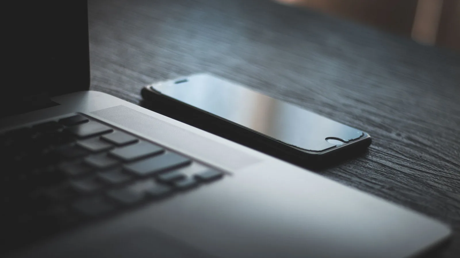 Laptop und Smartphone auf einem Arbeitstisch